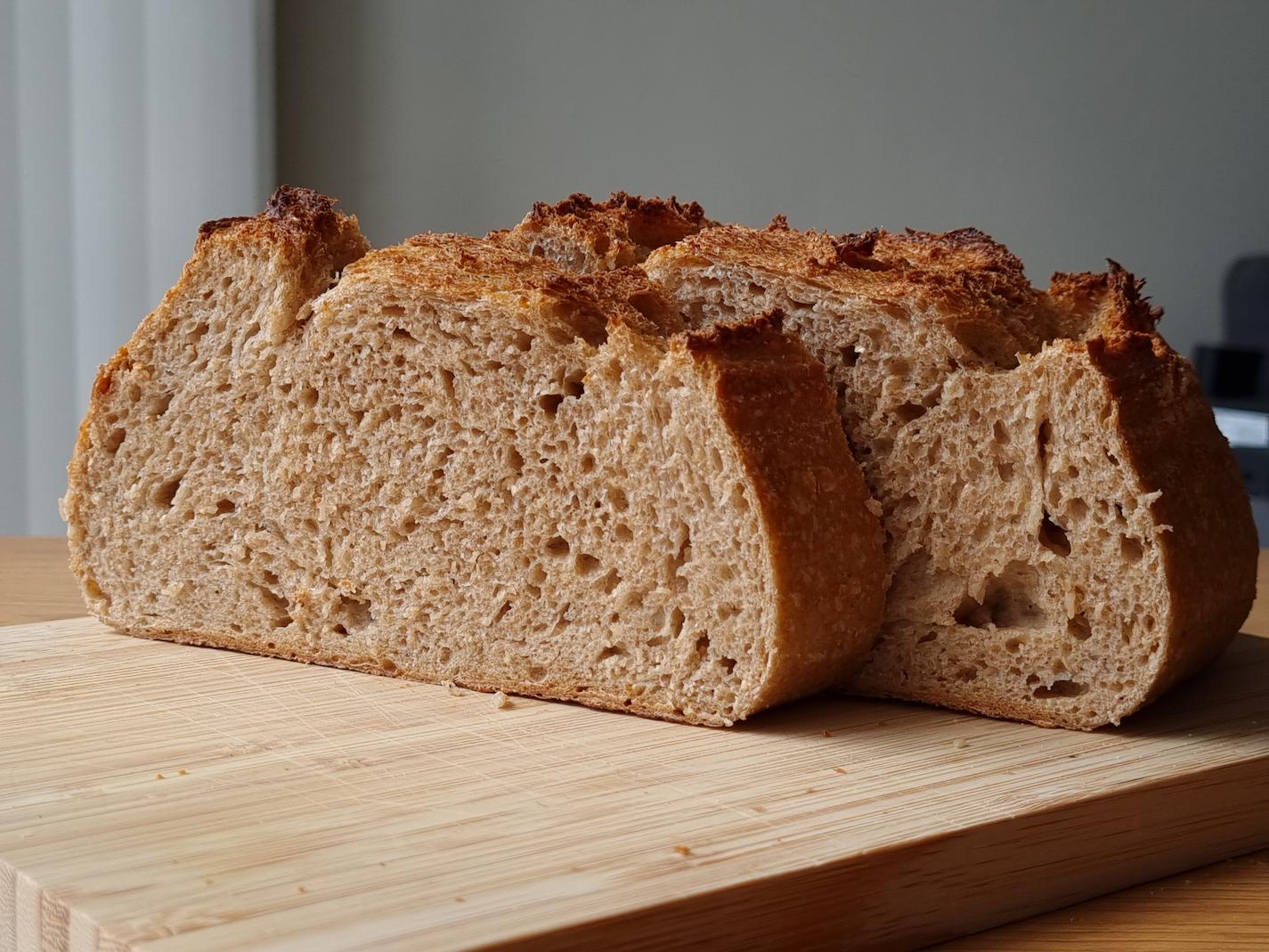 Slices of a spelt sourdough loaf, displayed on a wooden board.